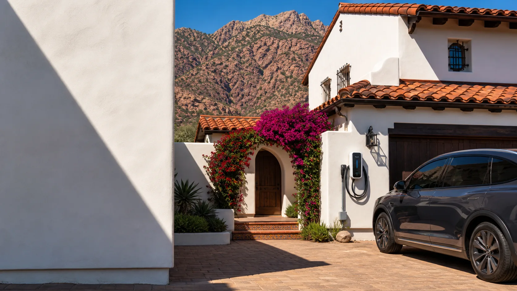 La Quinta Spanish colonial home in mid-morning sun with a wall charger, parked SUV, and red Santa Rosa Mountains
