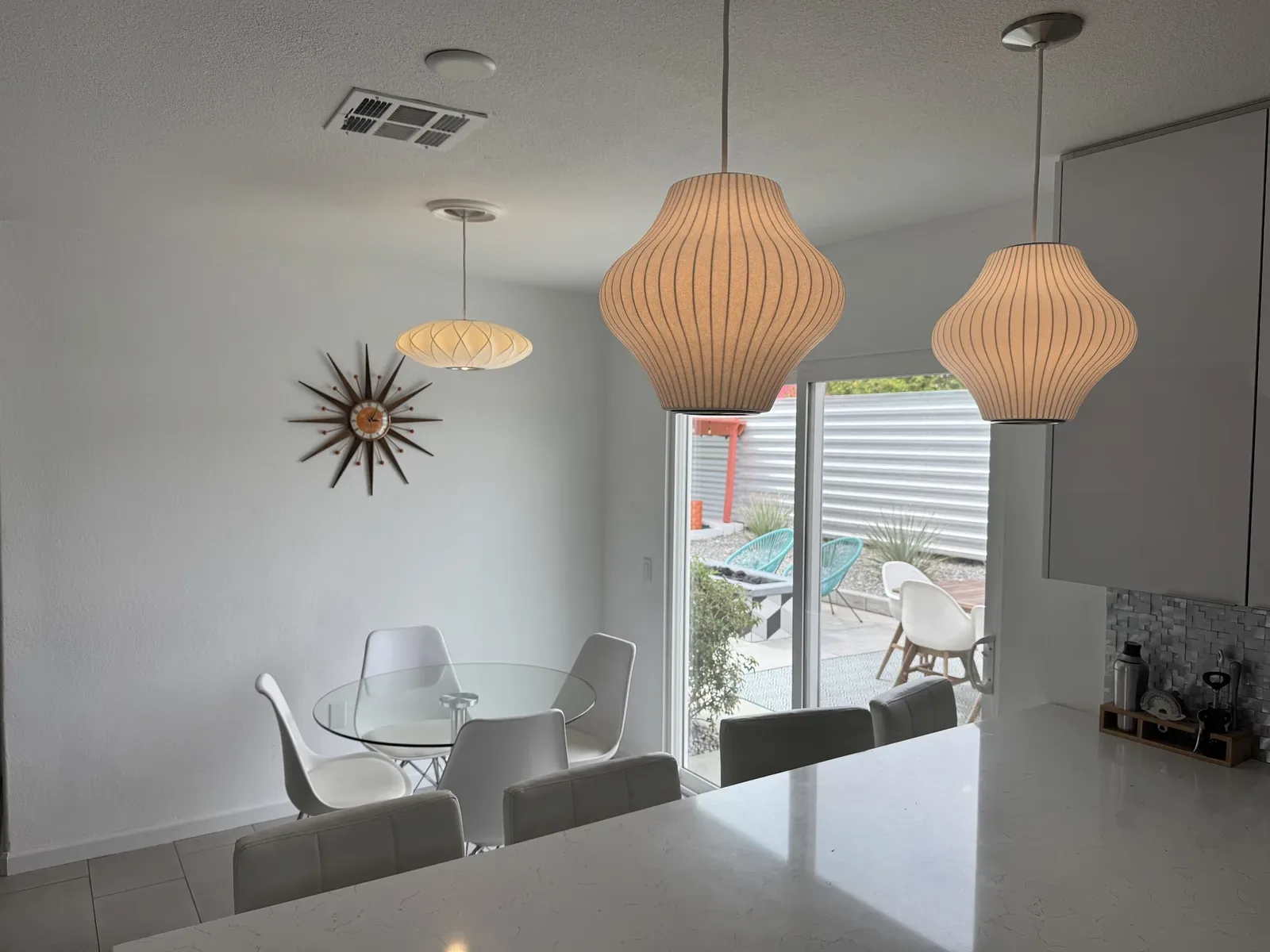 Mid-century pendant lights installed over a dining area